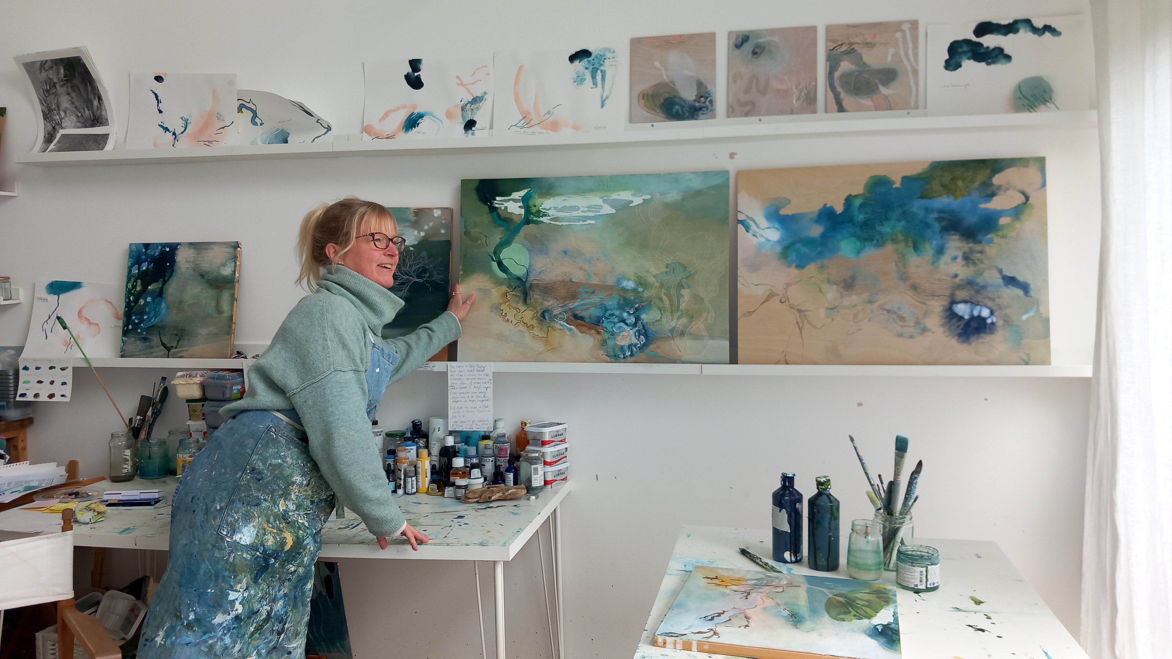 Tara Leaver in her art studio moving works in progress around
