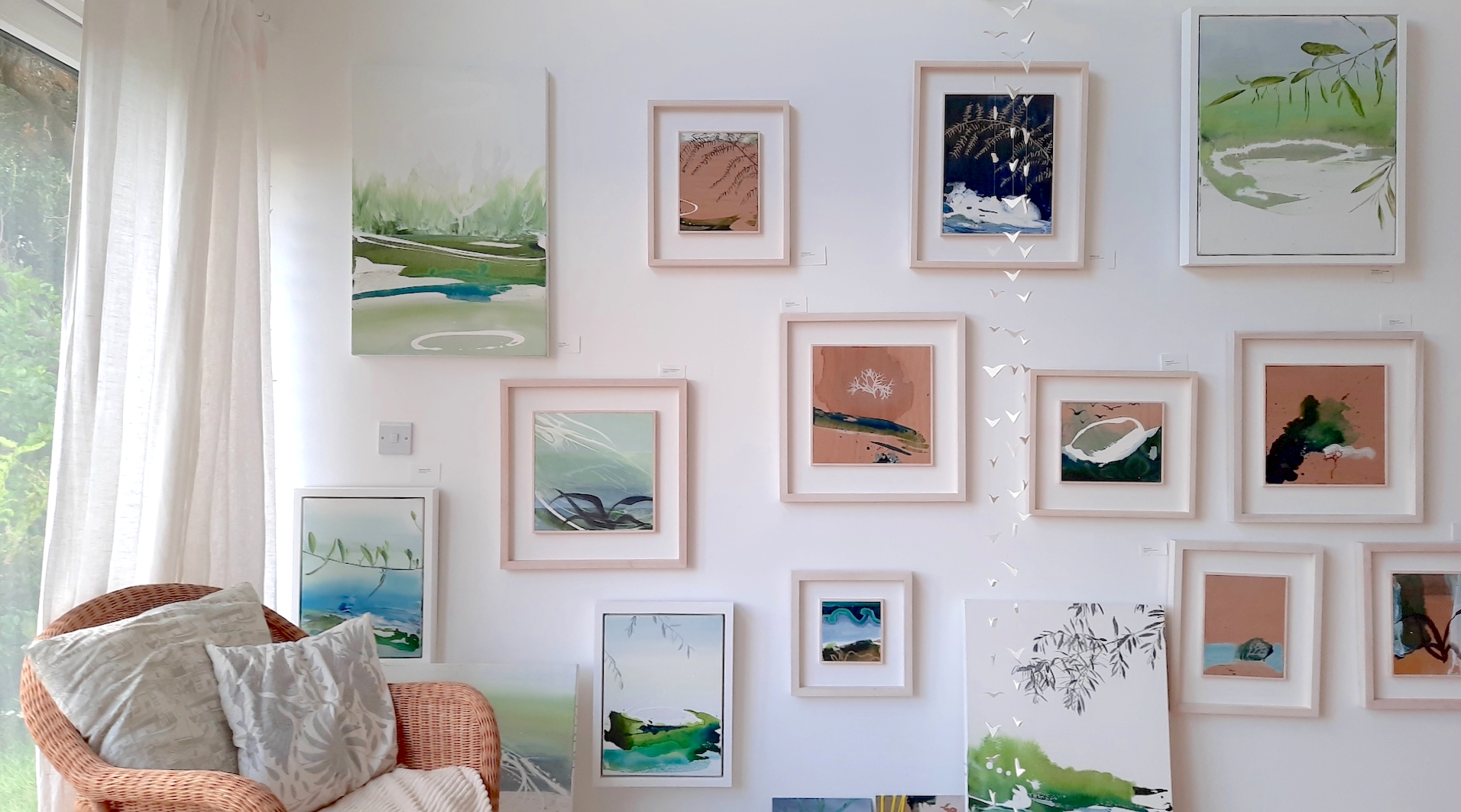 A selection of framed paintings by Tara Leaver hanging on the studio wall